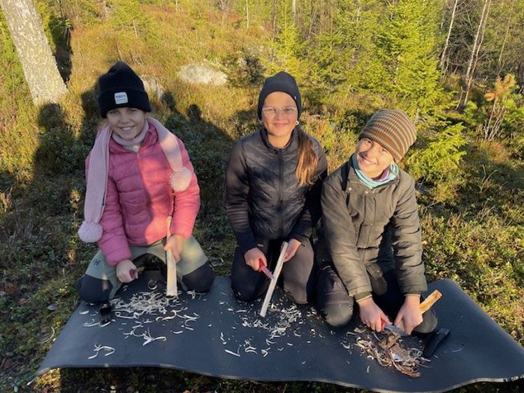 en gruppe mennesker som sitter på en flåte i en skog