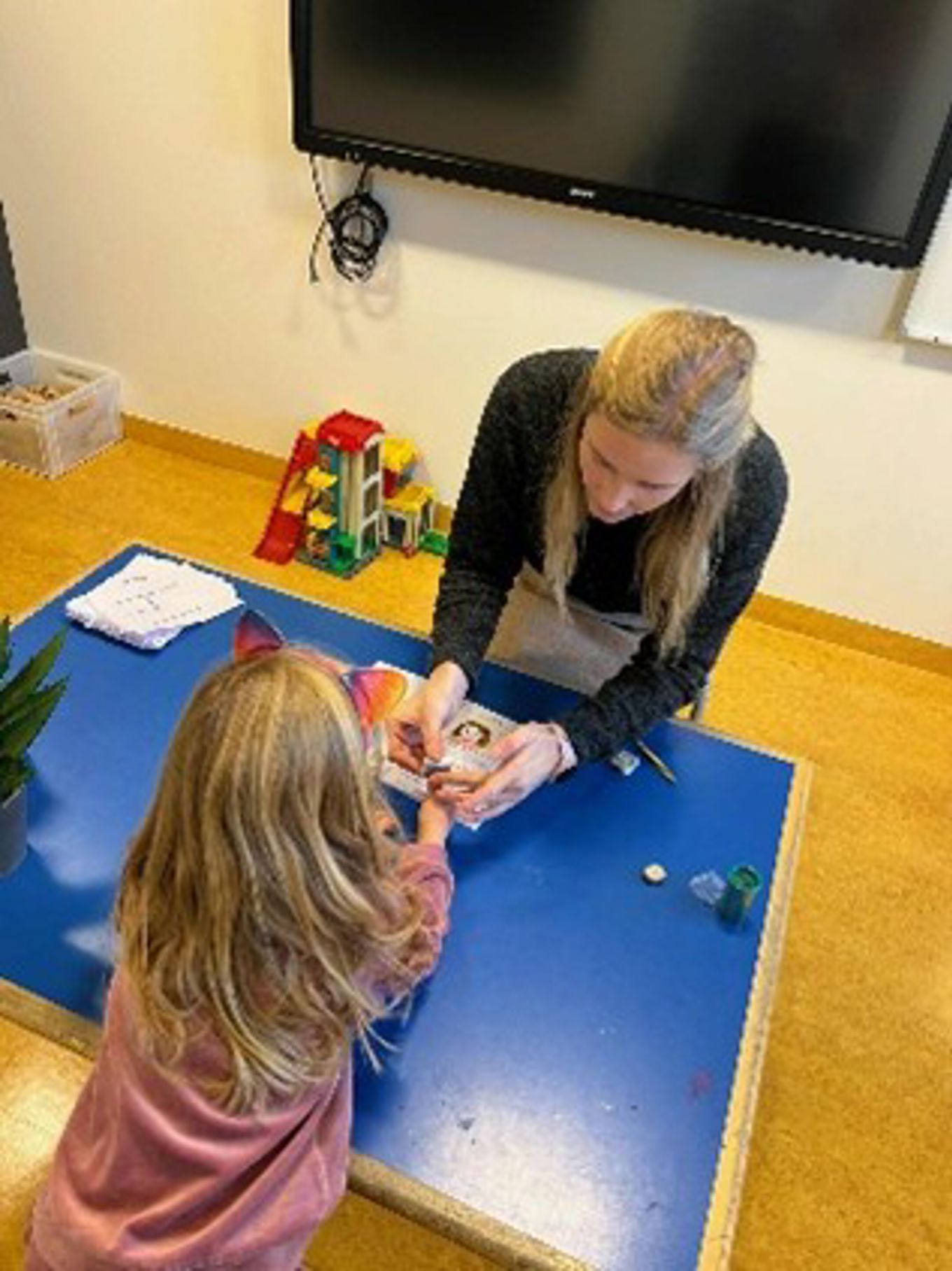 en person og et barn som spiller et spill på et bord en person og et barn som spiller et spill på et bord