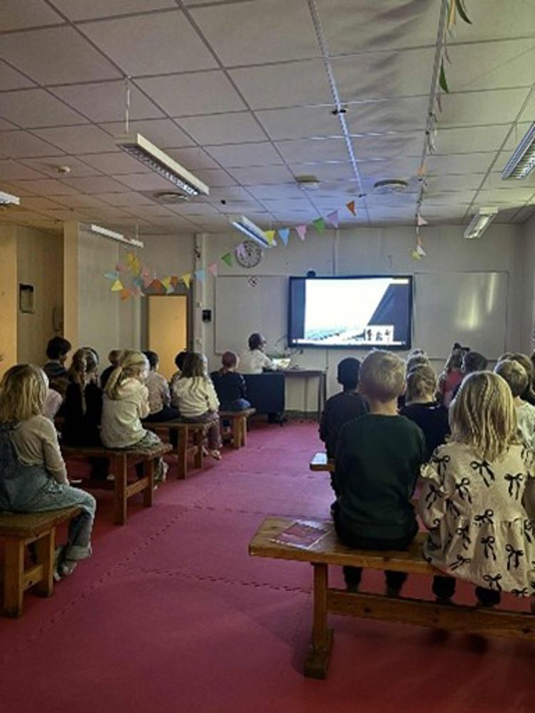 en gruppe mennesker som sitter i et rom og ser på en presentasjon