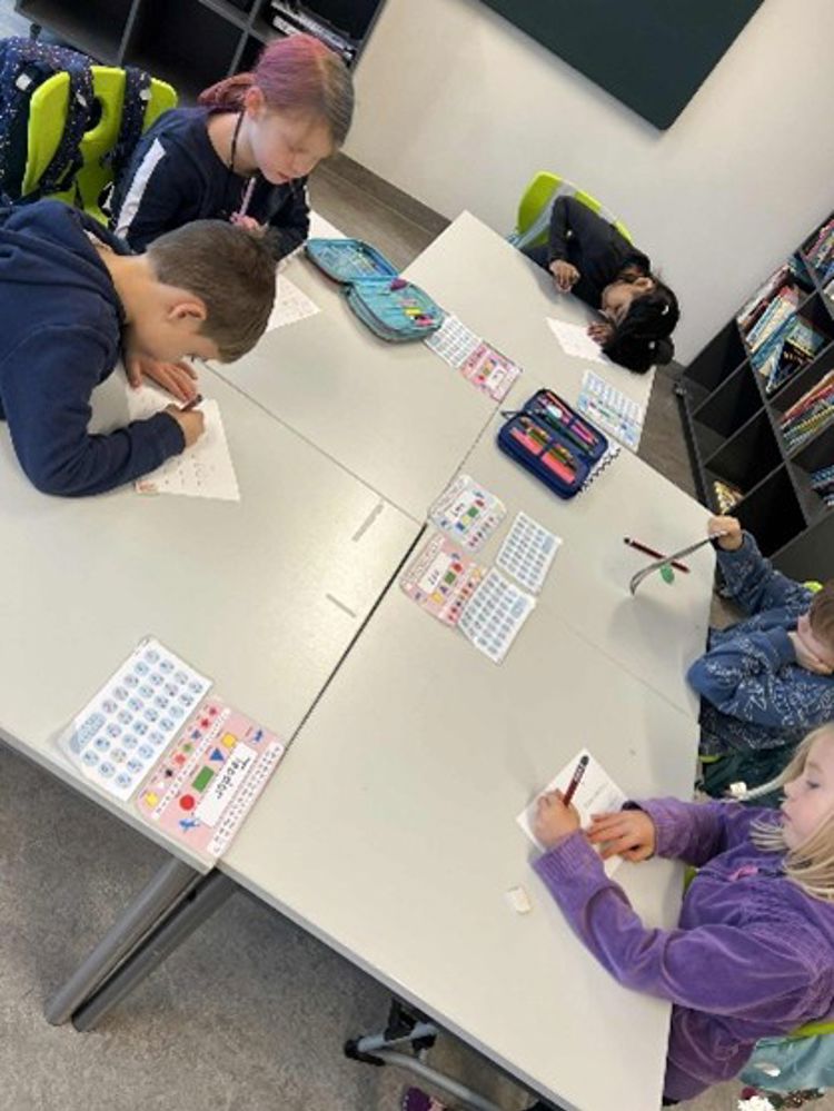 en gruppe mennesker som sitter ved et bord med papirer og tegninger på