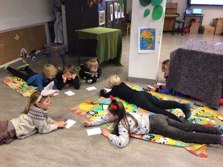 en gruppe barn som sitter på gulvet