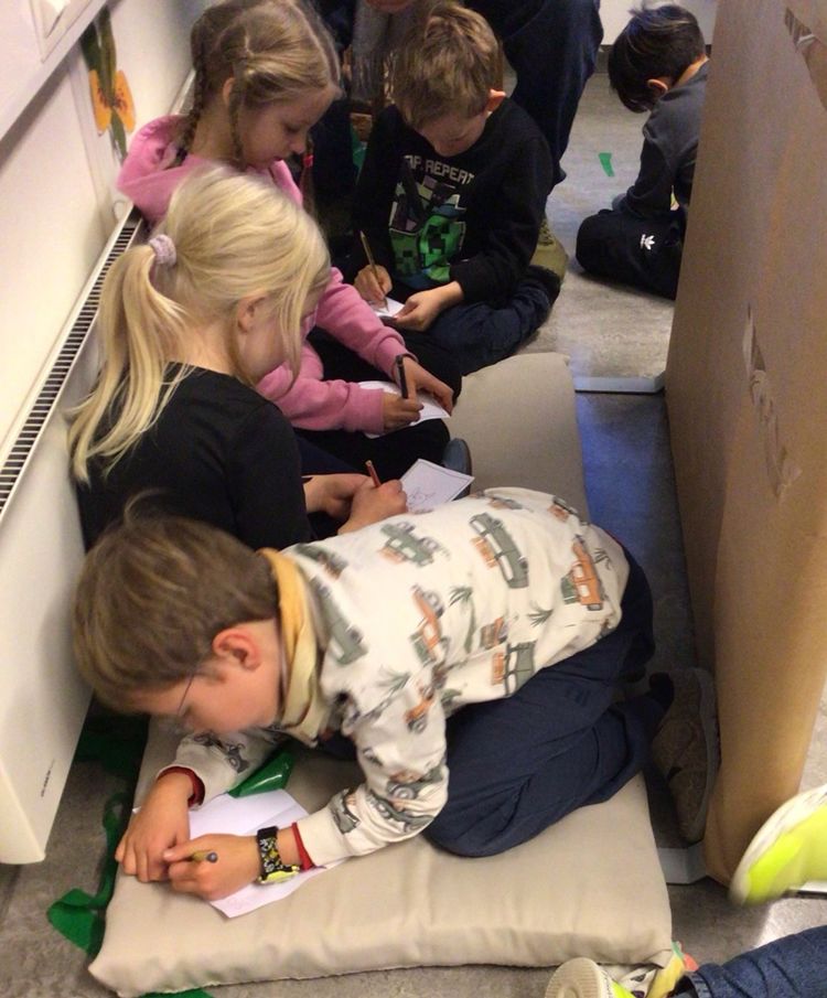 en gruppe barn som sitter på gulvet