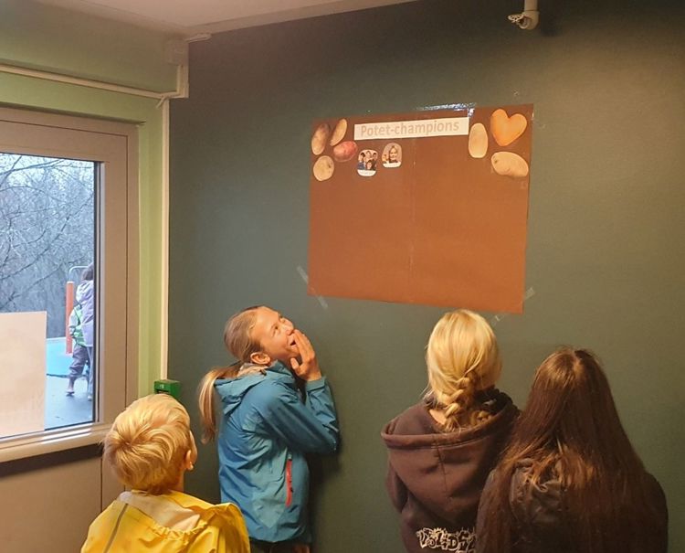 en gruppe mennesker som ser på en plakat på en vegg