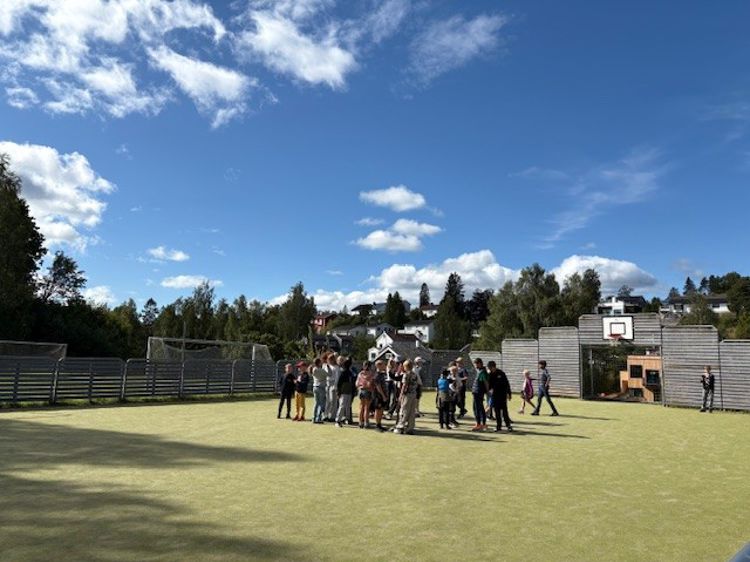 en gruppe mennesker som står på en gressbane en gruppe mennesker som står på en gressbane