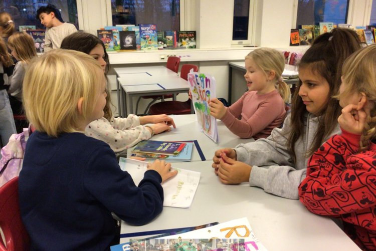 en gruppe barn som sitter ved et bord