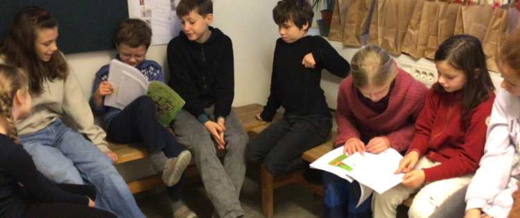 En gruppe mennesker som sitter i en sofa og ser på en bok