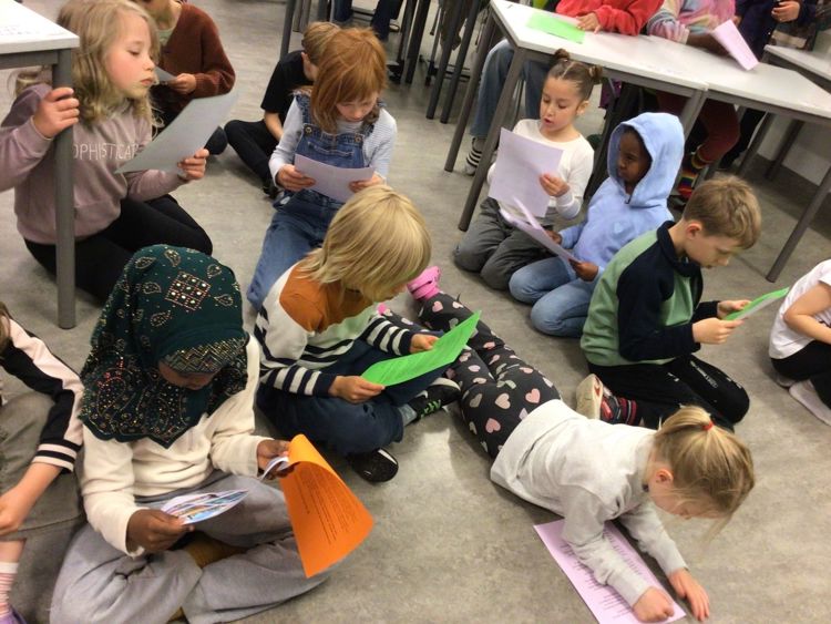 en gruppe barn som sitter på gulvet