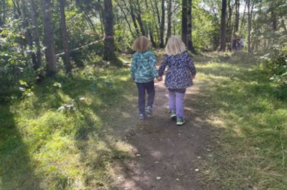 to barn som går på en grussti i skogen
