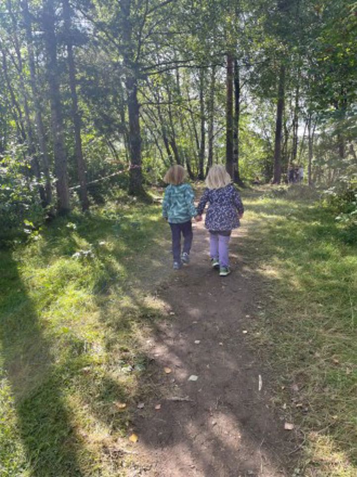 to barn som går på en grussti i skogen
