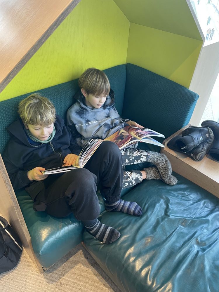 et par barner som sitter i en sofa og ser på en mobiltelefon