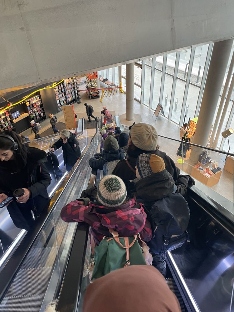 en gruppe mennesker i et stort rom med en stor glassvegg