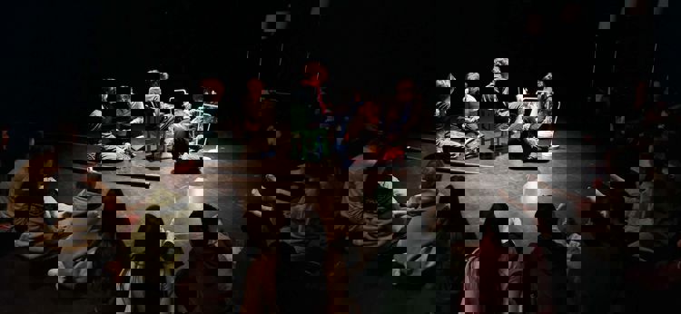 en gruppe mennesker som sitter på gulvet