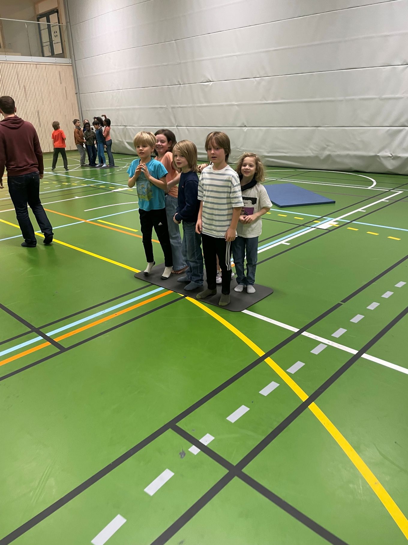 En gruppe barn som står på en grønn og gul sti