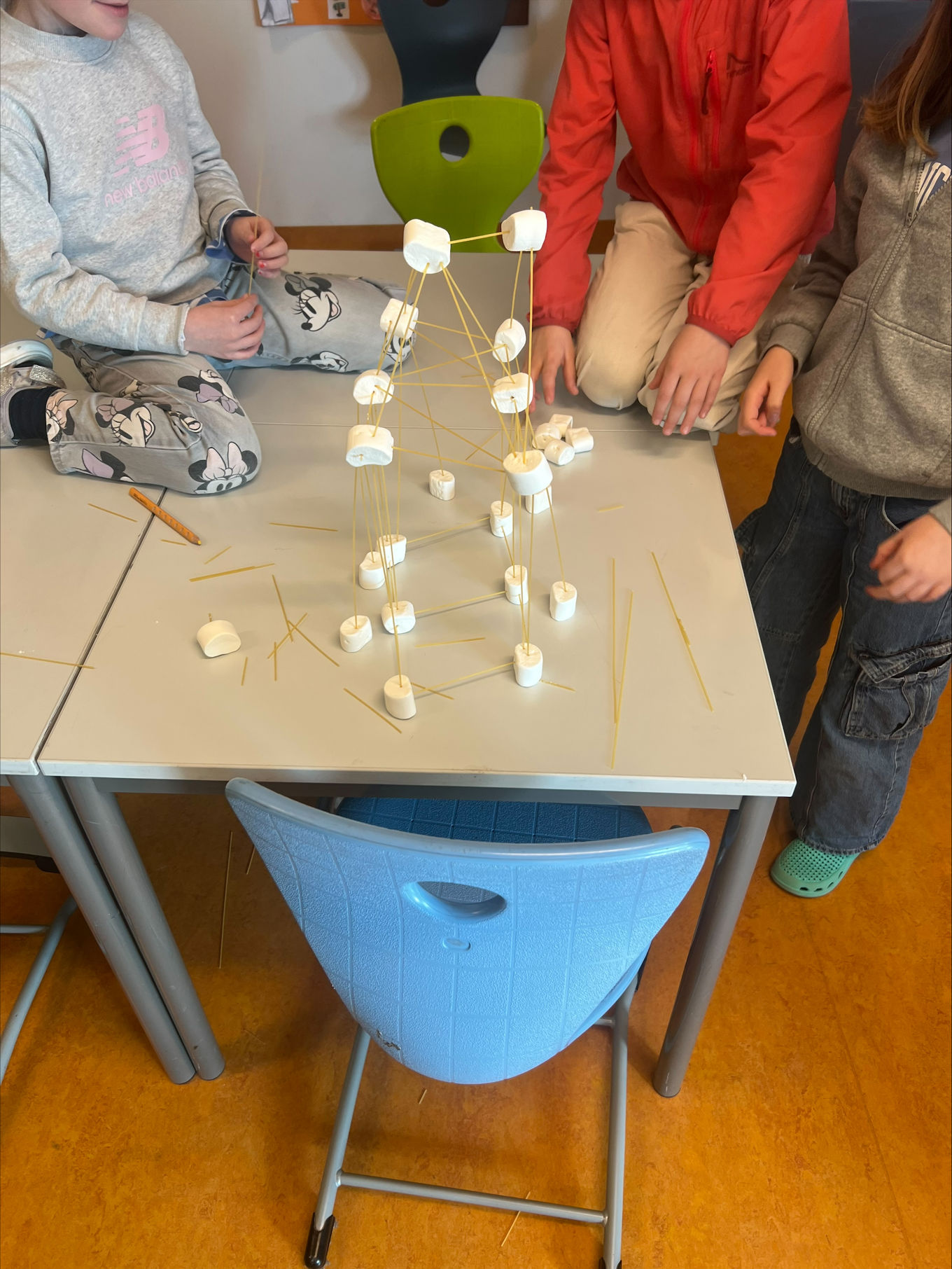 En gruppe mennesker rundt et bord med et sjakkbrett