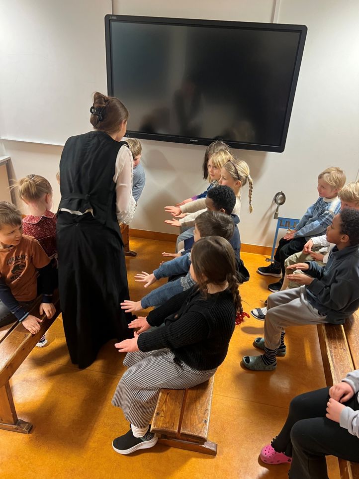 en gruppe mennesker som sitter i et rom og ser på en person som snakker