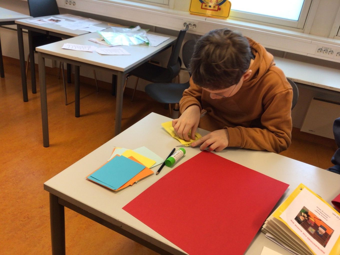 et barn som sitter ved et bord og skriver i en bok