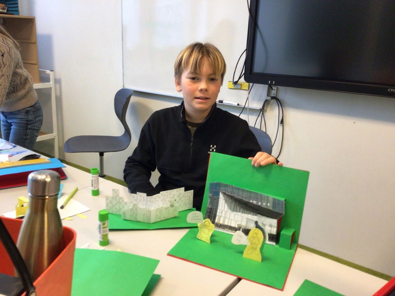 et barn som sitter ved et bord med en grønn eske og en grønn eske et barn som sitter ved et bord med en grønn eske og en grønn eske