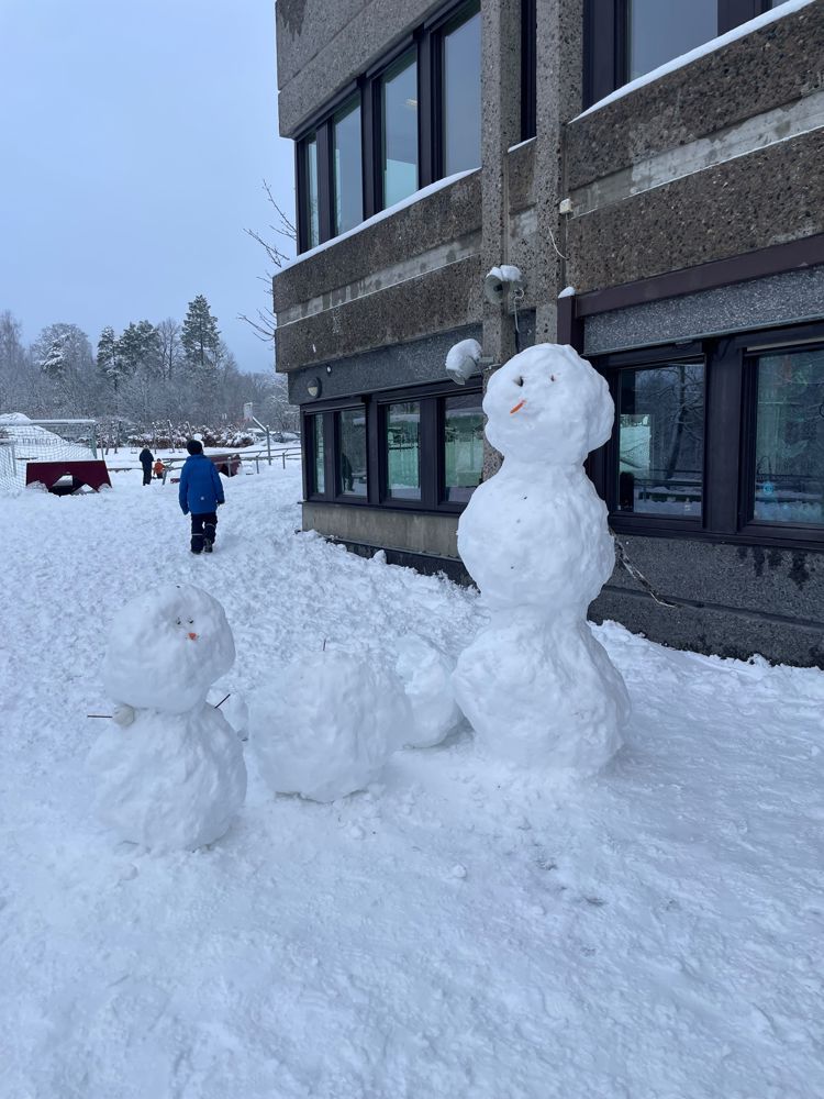 et par snømenn foran en bygning