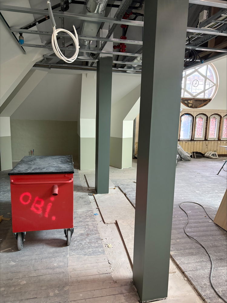 en stor metallkonstruksjon med en rød beholder foran