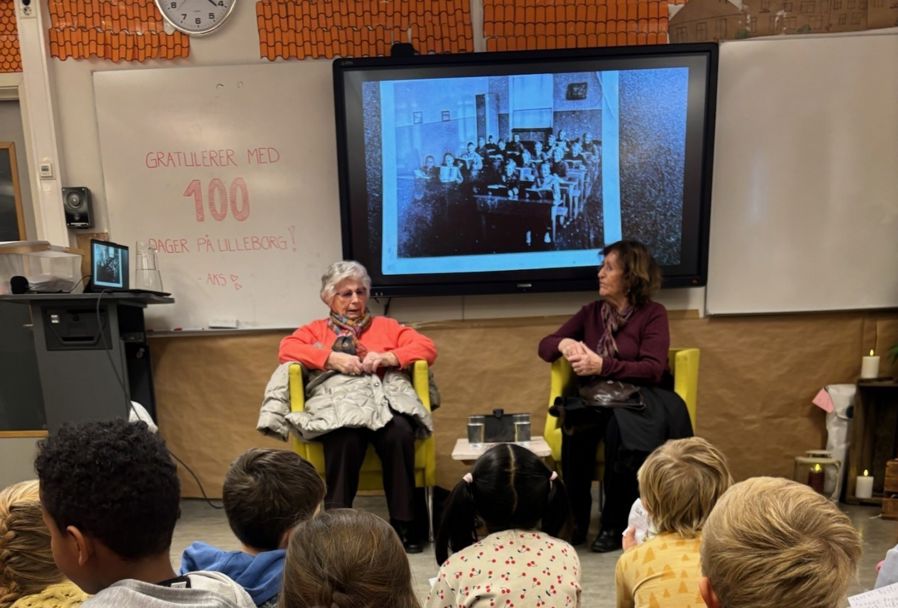 en person og en person som sitter foran en projektorskjerm