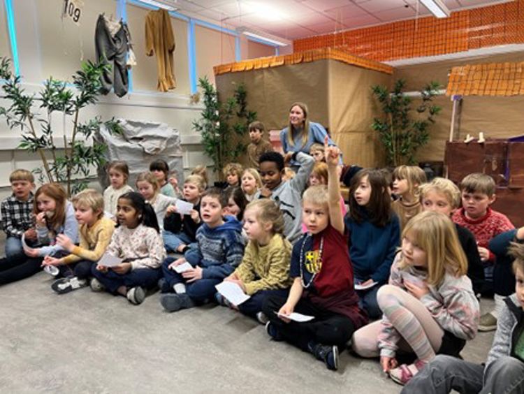 en gruppe mennesker som sitter på gulvet