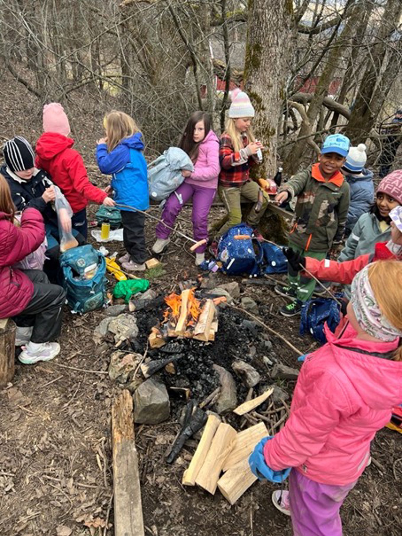 en gruppe mennesker som sitter rundt et bål en gruppe mennesker som sitter rundt et bål